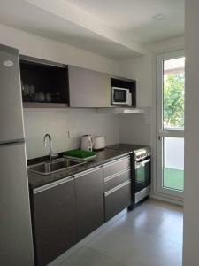 cocina con fregadero y microondas en Be Haus Temporary Apartments en San Luis