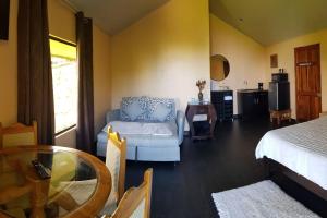 ein Wohnzimmer mit einem Sofa und einem Tisch in der Unterkunft Cabaña Montaña de Sueños in Quesada