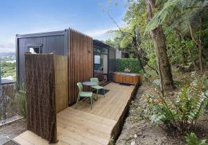 a small cabin with a table and chairs on a deck at 2 Peas In A Pod in Wellington