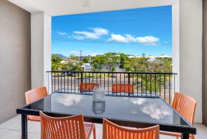 a table and chairs on a balcony with a view at The Loft Cairns in Cairns