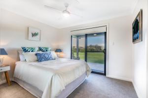 a bedroom with a bed and a sliding glass door at Clarrie's Green in Clarence Town