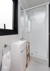 a white bathroom with a sink and a shower at 2 Peas In A Pod in Wellington