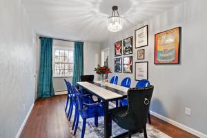 a dining room with a table and blue chairs at Stay Golden 1: Chic Modern-Victorian City View in Pittsburgh