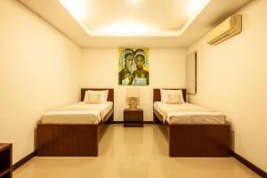 Pokój z dwoma łóżkami i obrazem na ścianie w obiekcie Sanur Beach Villa - 3BR Private Pool w mieście Sanur