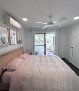 um quarto com uma cama grande e uma ventoinha de tecto em Unit 3 - Manly Boutique Apartments em Brisbane