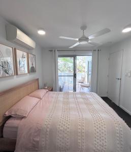 a bedroom with a large bed with a ceiling fan at Unit 3 - Manly Boutique Apartments in Brisbane