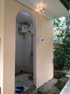 uma casa de banho com um chuveiro na parede em Mận Homestay - Lục Yên Homestay and Tour 