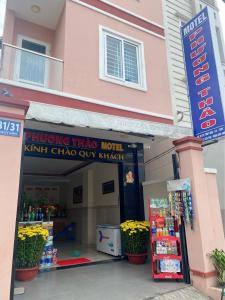 un bâtiment rose avec un panneau devant un magasin dans l'établissement Phương Thảo Motel (phòng đơn), à Vung Tau