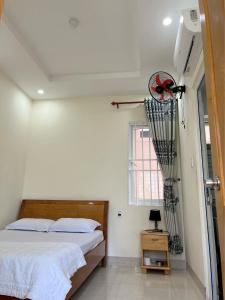 a bedroom with a bed and a fan on the wall at Phương Thảo Motel (phòng đơn) in Vung Tau