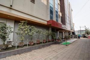 a building with potted trees on the side of it at Hotel The Furat Inn in Vapi