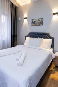 a bedroom with a large bed with white sheets and pillows at İSTANBLUE TAKSİM APART HOTEL in Istanbul