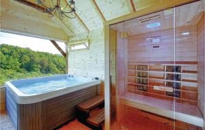 uma casa de banho com uma banheira e um chuveiro em vidro. em Cozy Home In Beretinec With Sauna em Beretinec