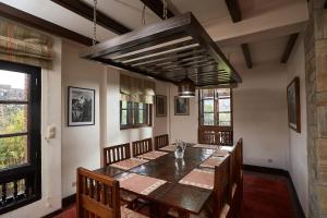 uma sala de jantar com uma mesa de madeira e cadeiras em Bandipur Bliss -- Villa - Hotel - Apartment - Cottage em Tanahun