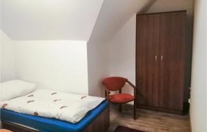 una camera con letto, sedia e armadio di Amazing Home In Ilawa With Wifi a Iława
