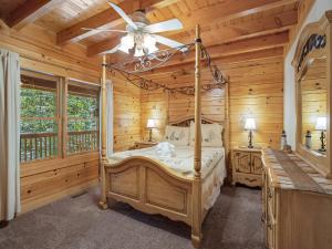 - une chambre avec un lit à baldaquin dans une cabane en rondins dans l'établissement Amazing River Retreat, 3 Bedrooms, WiFi, Sleeps 8, Pool Table, à Sevierville