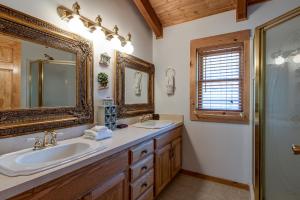 a bathroom with two sinks and a mirror at Amazing River Retreat in Sevierville +36 photos