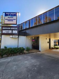 un estacionamiento frente a un edificio con un cartel en Barham Bridge Motor Inn, en Barham