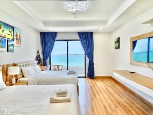 um quarto de hotel com duas camas e vista para o oceano em TMS Quy Nhơn View Biển em Quy Nhon