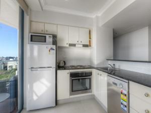 a kitchen with a white refrigerator and a stove at Shevlin Apartments in Brisbane