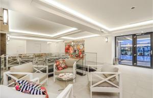 Prora Solitaire Avida Loft13 في بينز: غرفة بها كراسي بيضاء وطاولات ونوافذ
