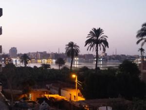 Blick auf eine Stadt mit Palmen in der Nacht in der Unterkunft King Tut in Al Aqālitah