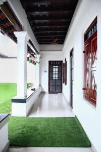 un couloir d'une maison avec un tapis vert dans l'établissement Bobbys Corner, à Alappuzha