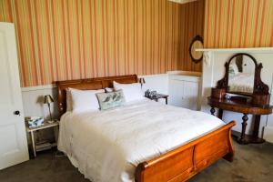 a bedroom with a large bed and a table at Taieri Bank Cottage - Middlemarch, Otago in Middlemarch