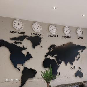 a wall with clocks and a map of the world at Port Suites Hotel in Bursa