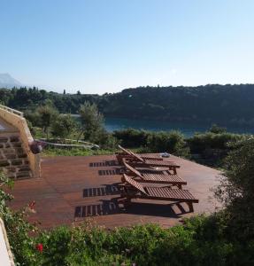 a bunch of chairs sitting on a deck with a lake at Katikies Manis in Kardamyli