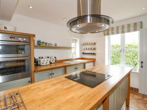 a kitchen with a wooden counter top and a stove at Highfield House in Leek