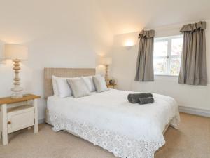 a bedroom with a white bed and a window at Highfield House in Leek