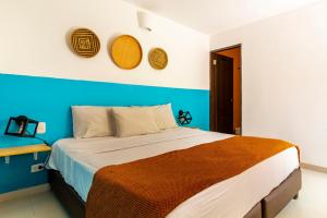 una camera con un letto con una parete blu di Gagaka Rua hostel a Santa Marta