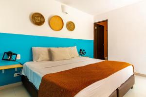 a bedroom with a bed with a blue wall at Gagaka Rua hostel in Santa Marta