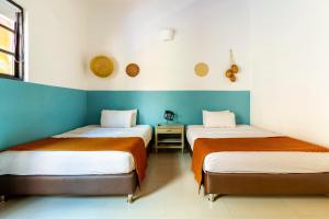 2 Betten in einem Zimmer mit blauen und weißen Wänden in der Unterkunft Gagaka Rua hostel in Santa Marta