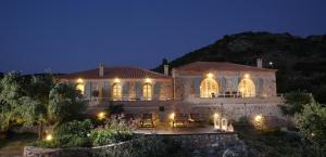 a large stone house with lights on it at night at Katikies Manis in Kardamili