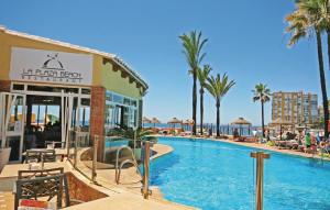 a pool at a resort with palm trees and a hotel at Bella Vista Hills in Mijas Costa