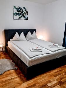 1 dormitorio con 1 cama grande con sábanas blancas en Apartament Alina, en Deva