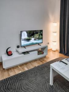 a living room with a flat screen tv on a white entertainment center at Apartament Alina in Deva