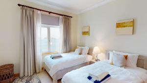 a hotel room with two beds and a window at Al Dabas Beach Views, 3BD Sleeps 6, Beachfront Beach & Pool Access in Dubai