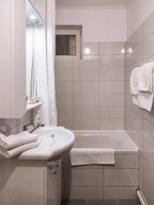 a white bathroom with a sink and a bath tub at Apartament Alina in Deva