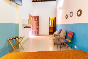 a living room with blue and white walls and chairs at Gagaka Rua hostel in Santa Marta