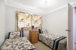 a bedroom with two beds and a window at Carlaminda Peregian Beach in Peregian Beach