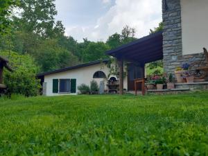 a house with a green lawn in front of it at La Lacia in Acqui Terme