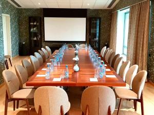 a long table in a room with chairs and a screen at Badam d'Art Boutique Hotel in Baku