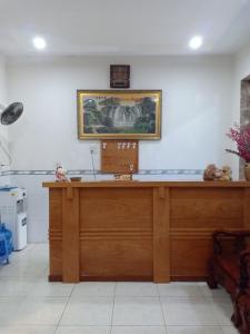 uma secretária num quarto com uma fotografia na parede em Manh Phat Guesthouse - Nhà Nghỉ Mạnh Phát em Can Tho