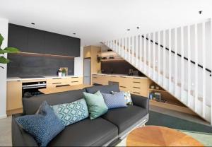 a living room with a couch and a staircase at Cardrona Black Diamond Apartment in Cardrona