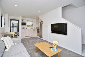 a living room with a couch and a table at Sea air and Sandy Beach, beautiful 1 bed 1 bath in Christchurch