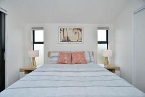 um quarto branco com uma cama grande e 2 candeeiros em Sea air and Sandy Beach, beautiful 1 bed 1 bath em Christchurch