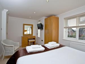 a bedroom with a large bed with two white towels at 7 Goodrington Lodge in Paignton