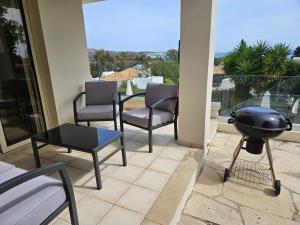un patio con sillas, una parrilla y una mesa en Villa Felix, en Bahía de Coral